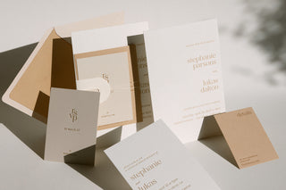 A collection of wedding invitation cards with various wording examples on display